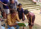 Thailand-Laos 2002 325  Eskil viser en pige en bog blandt flere som bliver doneret til landsbyens skole Laos